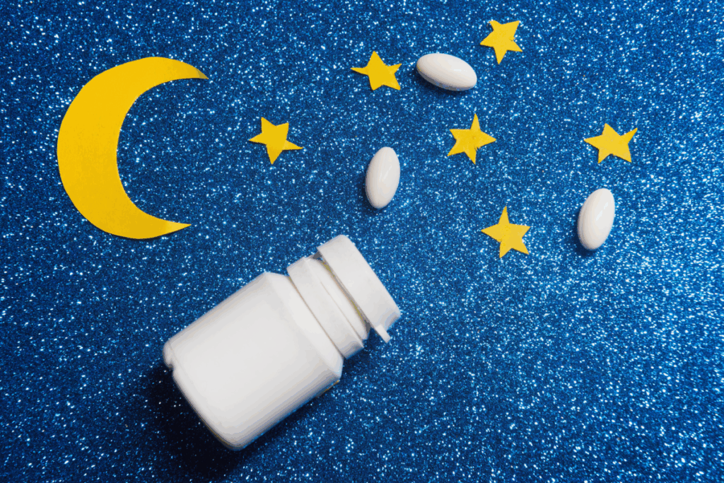 A pill box, three pills , 5 star and one moon stickers arranged on a blue background