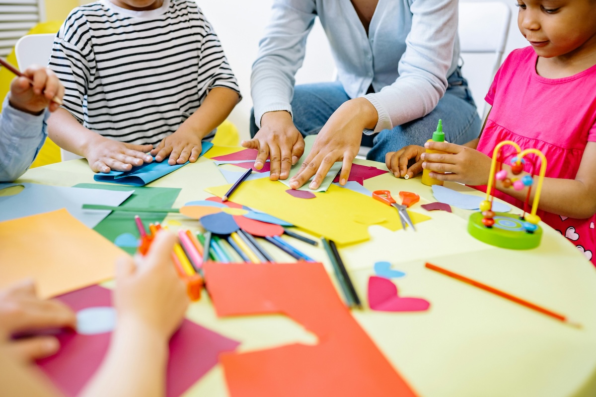 Children doing crafts with teacher in class.