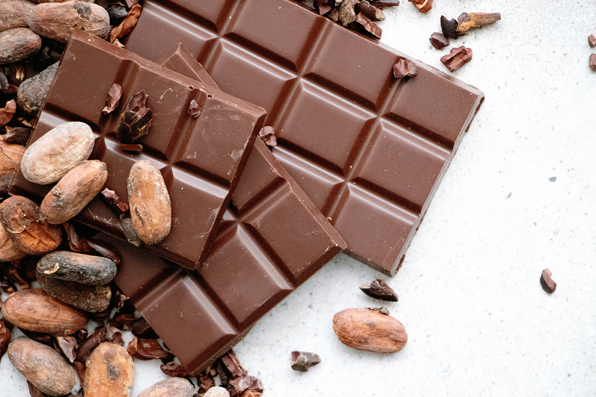 A pile of chocolate bars and nuts on a white background.