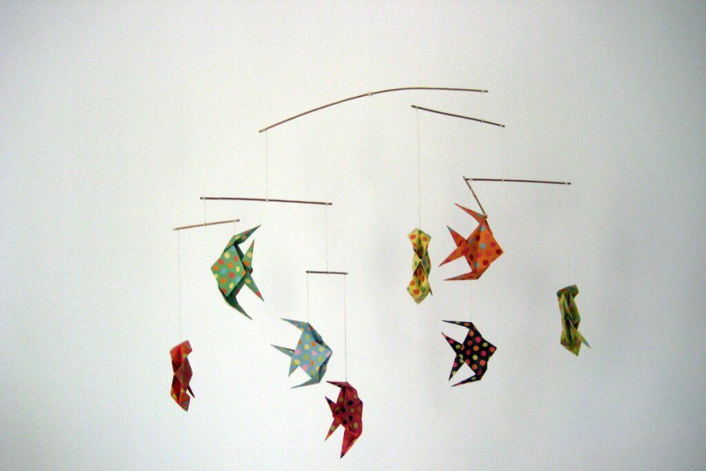 A mobile made of colorful origami fish on a white background.