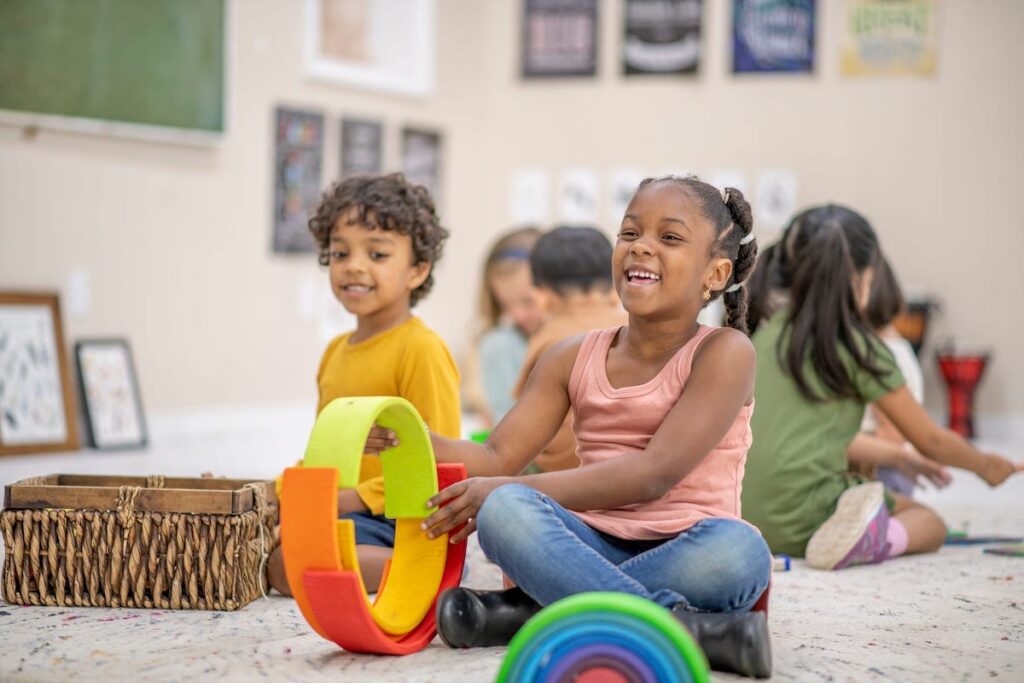 Kids in a classroom play with Montessori-style toys.