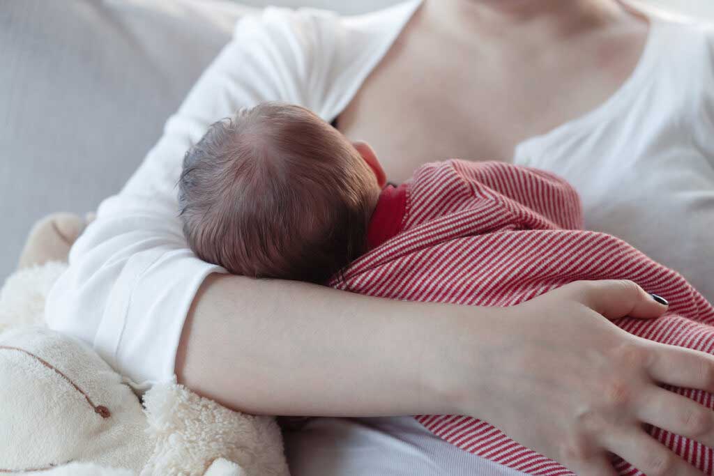 Parent breastfeeds a baby.