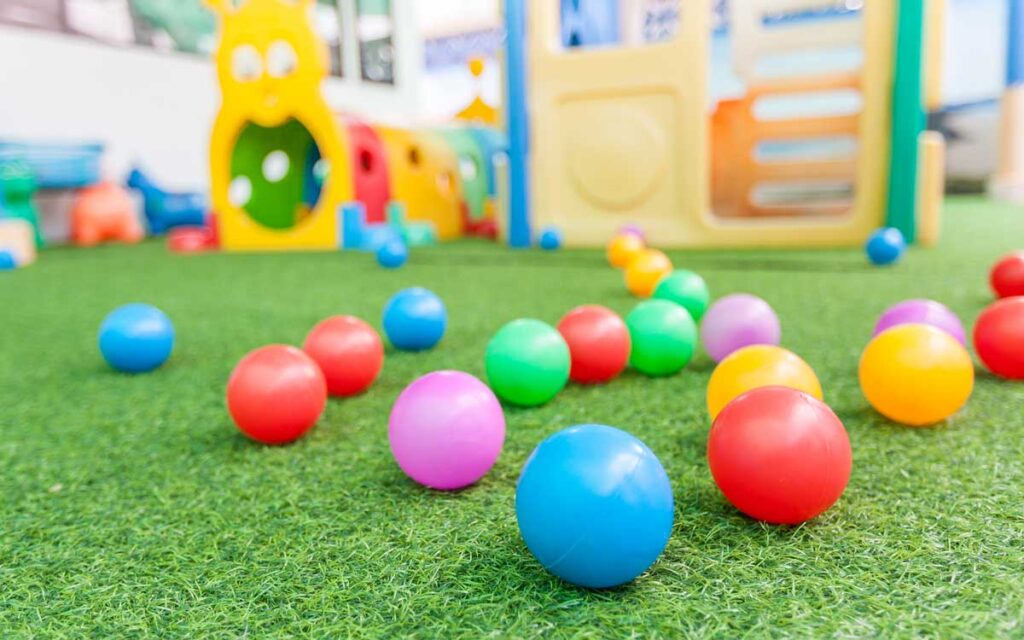 Plastic children's toys are arranged on an astroturf lawn.