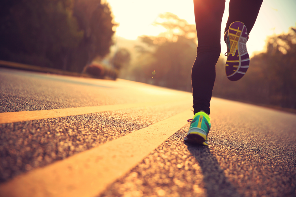 Close up of a person jogging at sunrise.