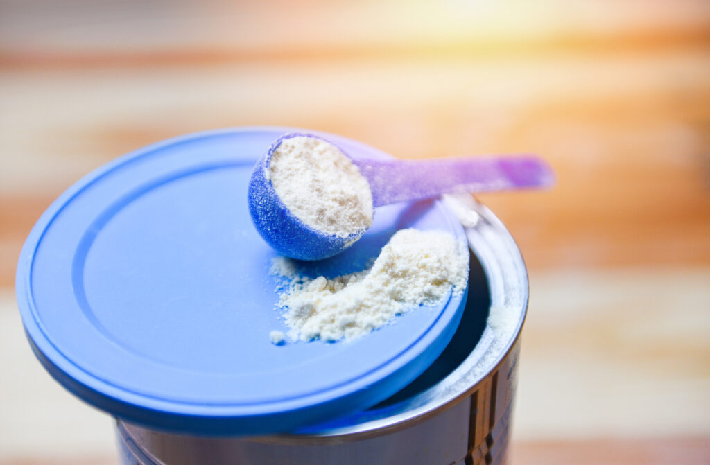 A spoon for formula powder is seen on top of the formula can.