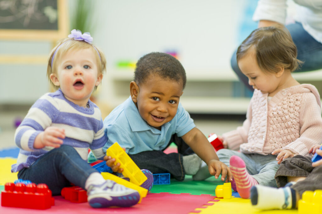 Babies playing on the carpet at day care.