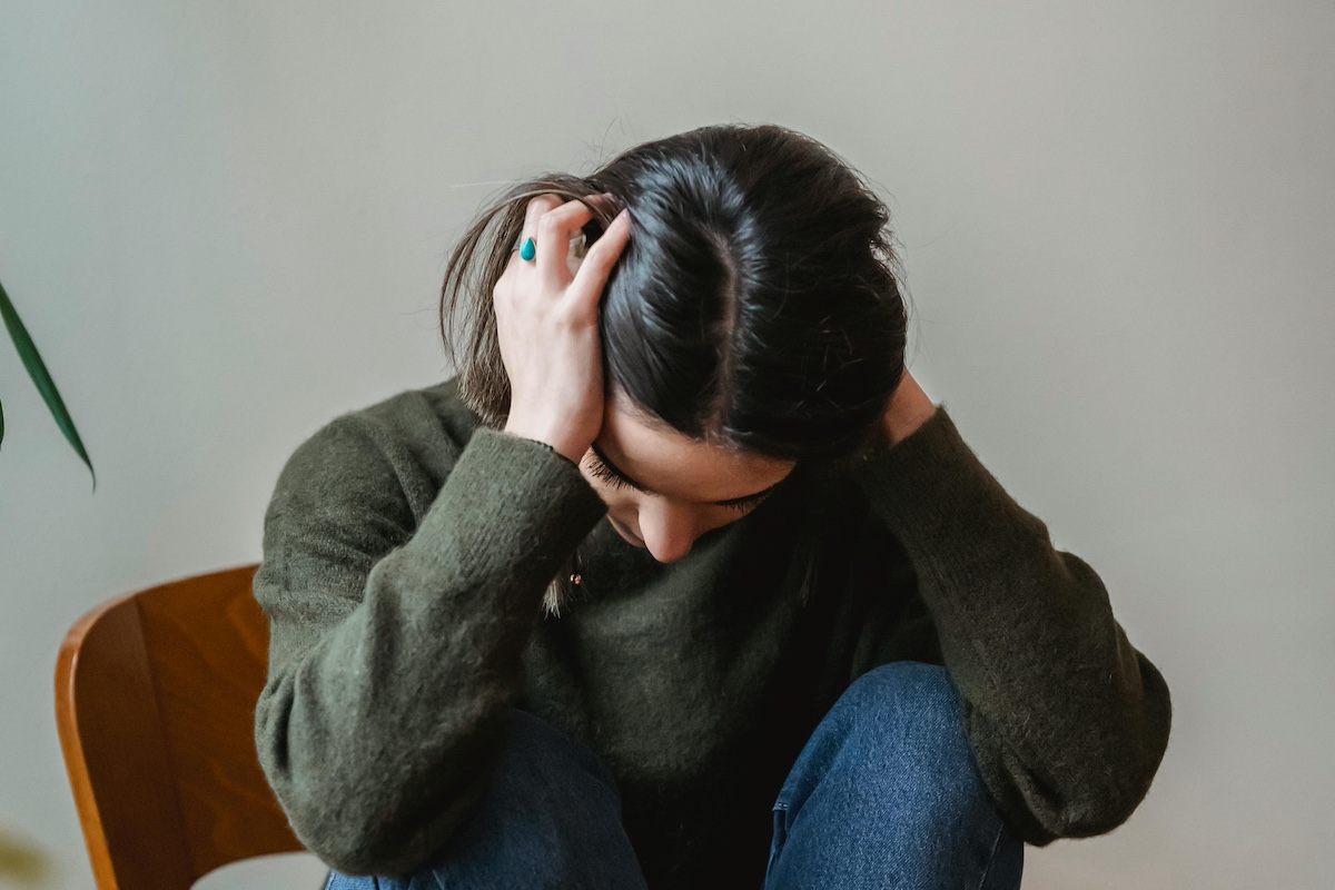 Frustrated person with head in hands