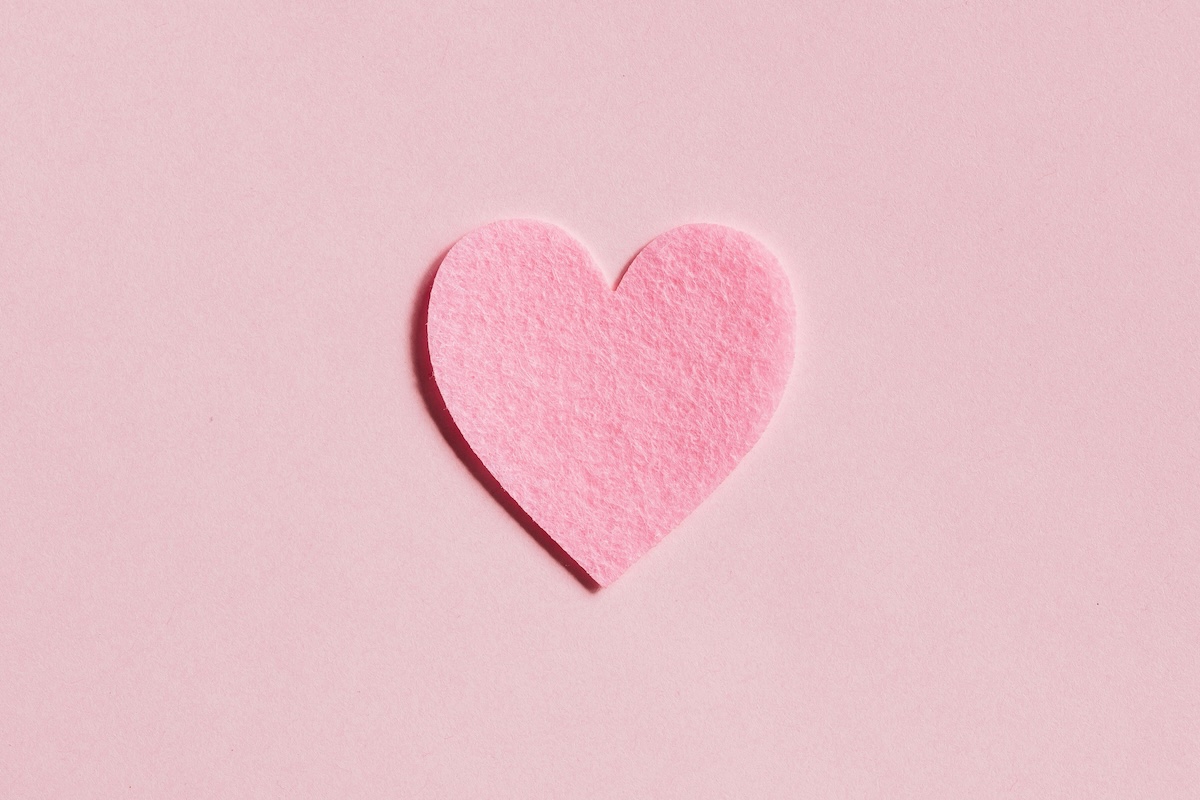 Pink felt heart on pink background