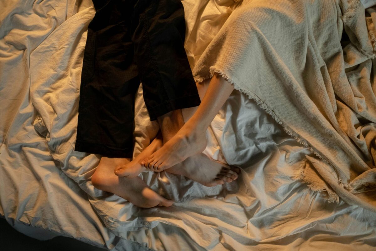 Two people in bed with feet intertwined