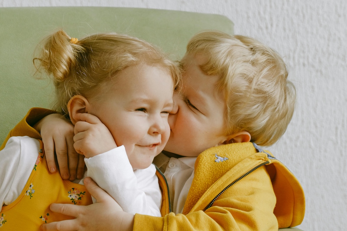 Toddler kissing another toddler