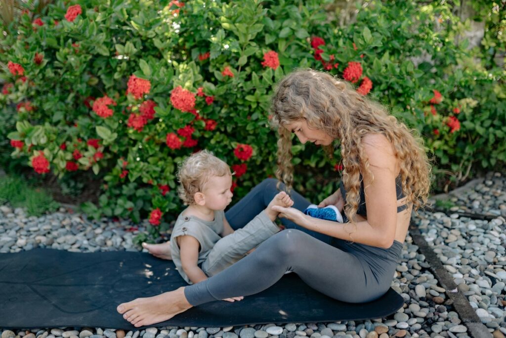Adult in fitness clothing on floor with toddler
