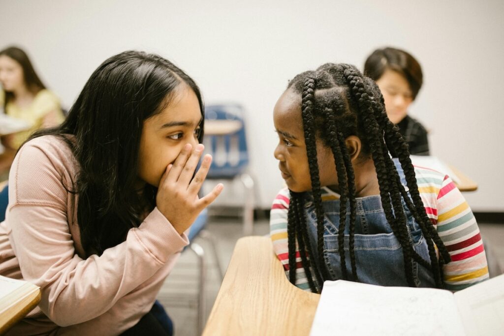 two kids talking in a class room