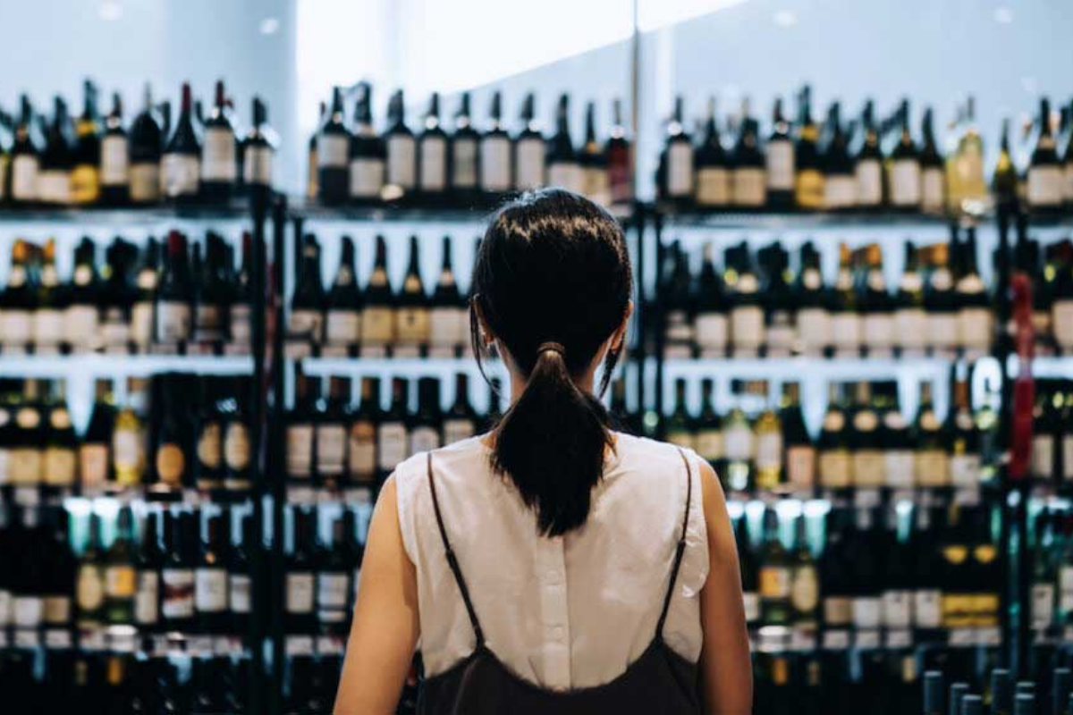 A person looking at alcohol rack.