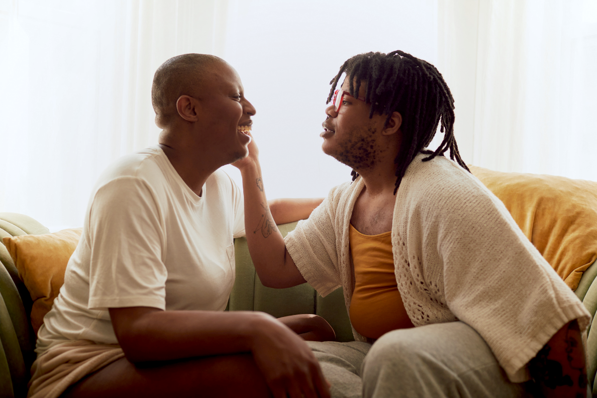 Two people sitting on the couch and looking at each other