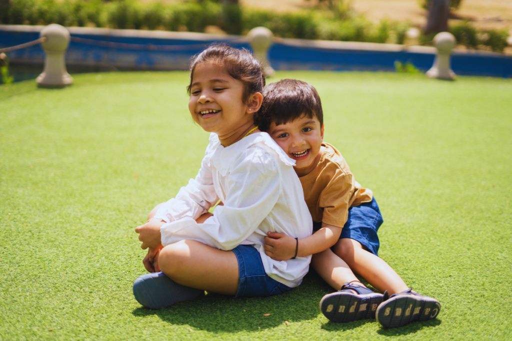 Two siblings outdoor sitting and embracing each other.