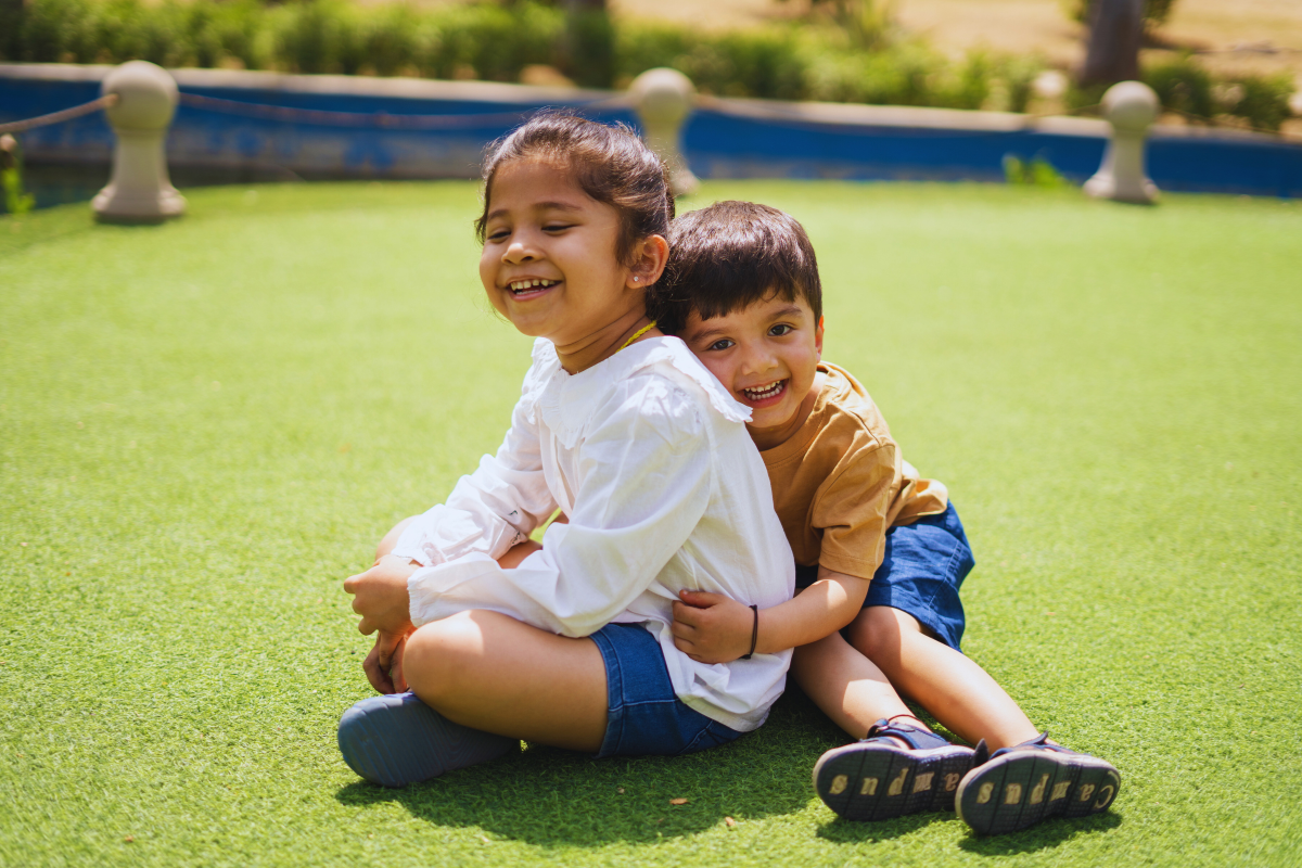 Two siblings outdoor sitting and embracing each other.