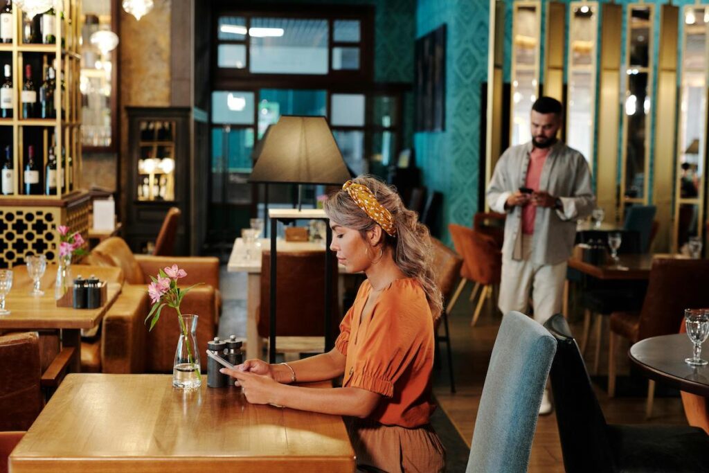 A person sitting in a restaurant and looking at their phone.