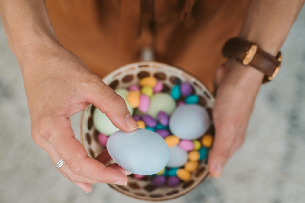 A person taking an egg from a basket of eggs