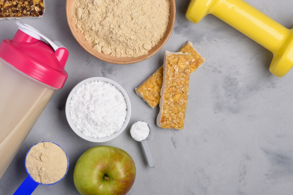 Protein shake, crackers, bar, powder, small weight and an apple