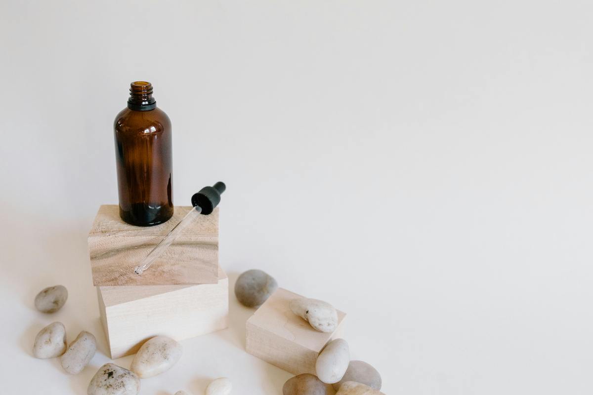 An open oil bottle on a wooden plank surrounded by smaller planks and stones.