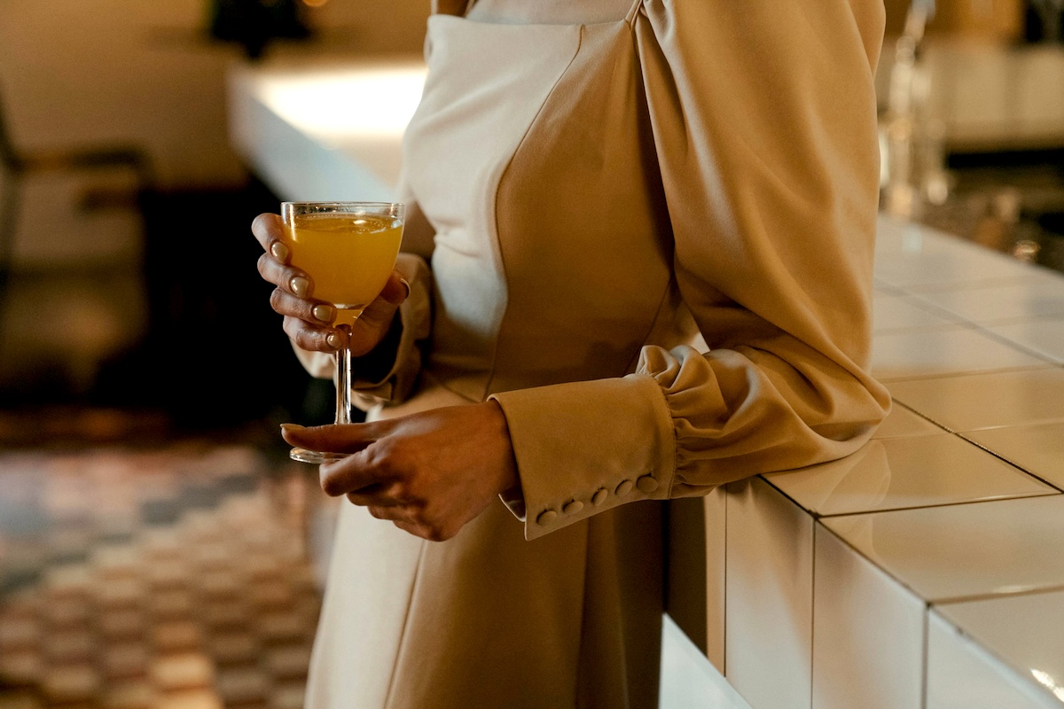 A person standing with a drink in hand.