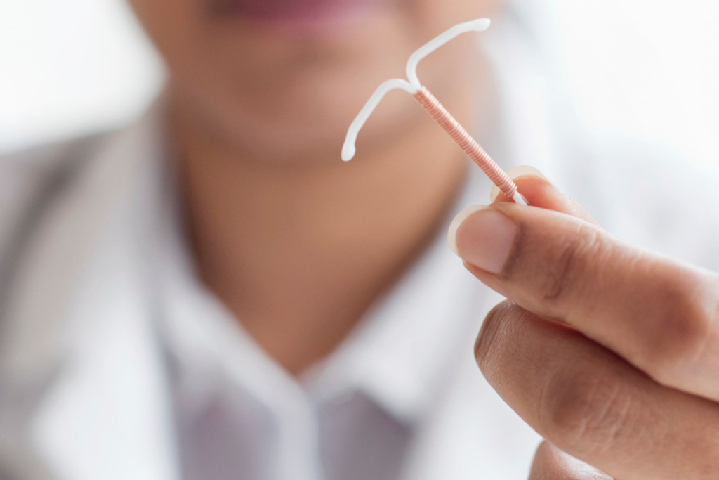A doctor holding an IUD.