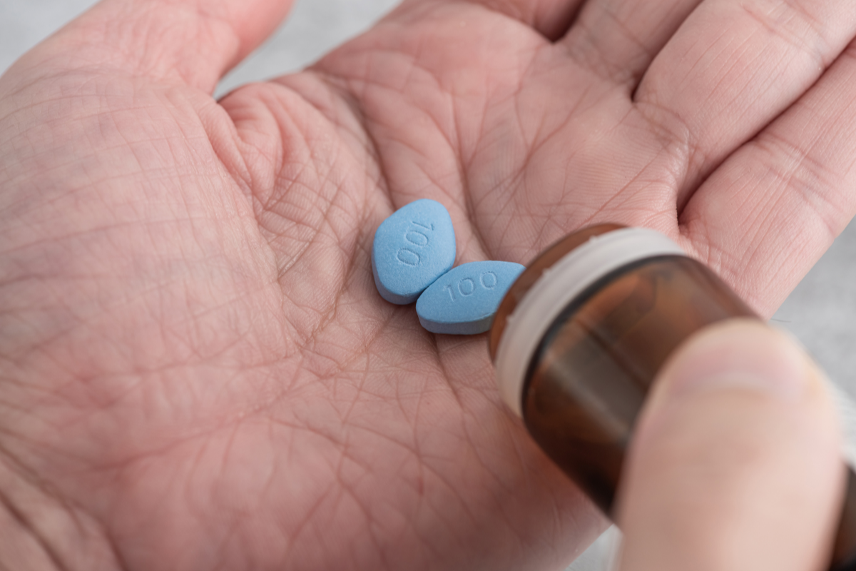 A person popping Viagra pills in hand.