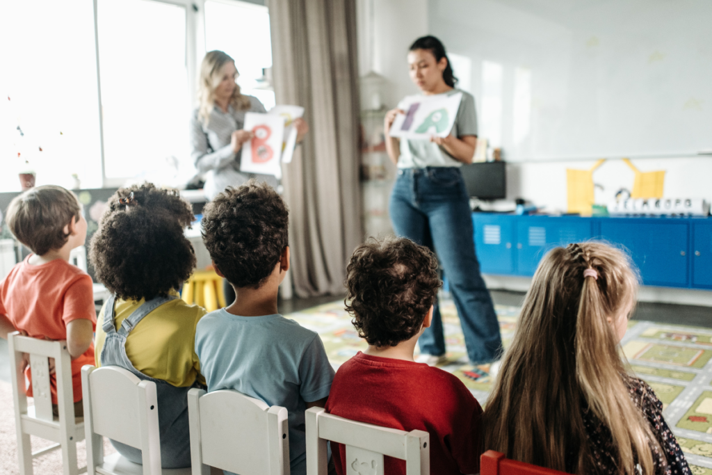 A teacher teaching kindergarten kids in a classroom.