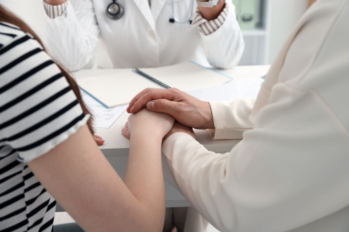 A couple holding hands in a doctor's office.