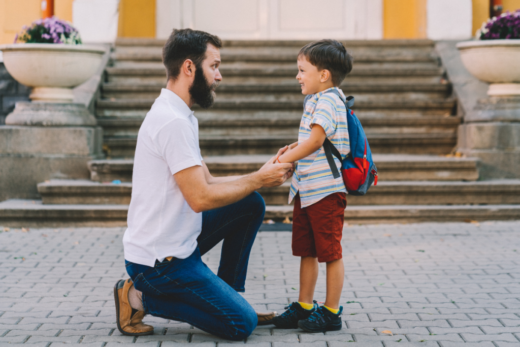 A father holding the hands of his son.