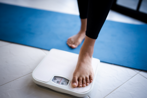 A person stepping on a weighing scale.